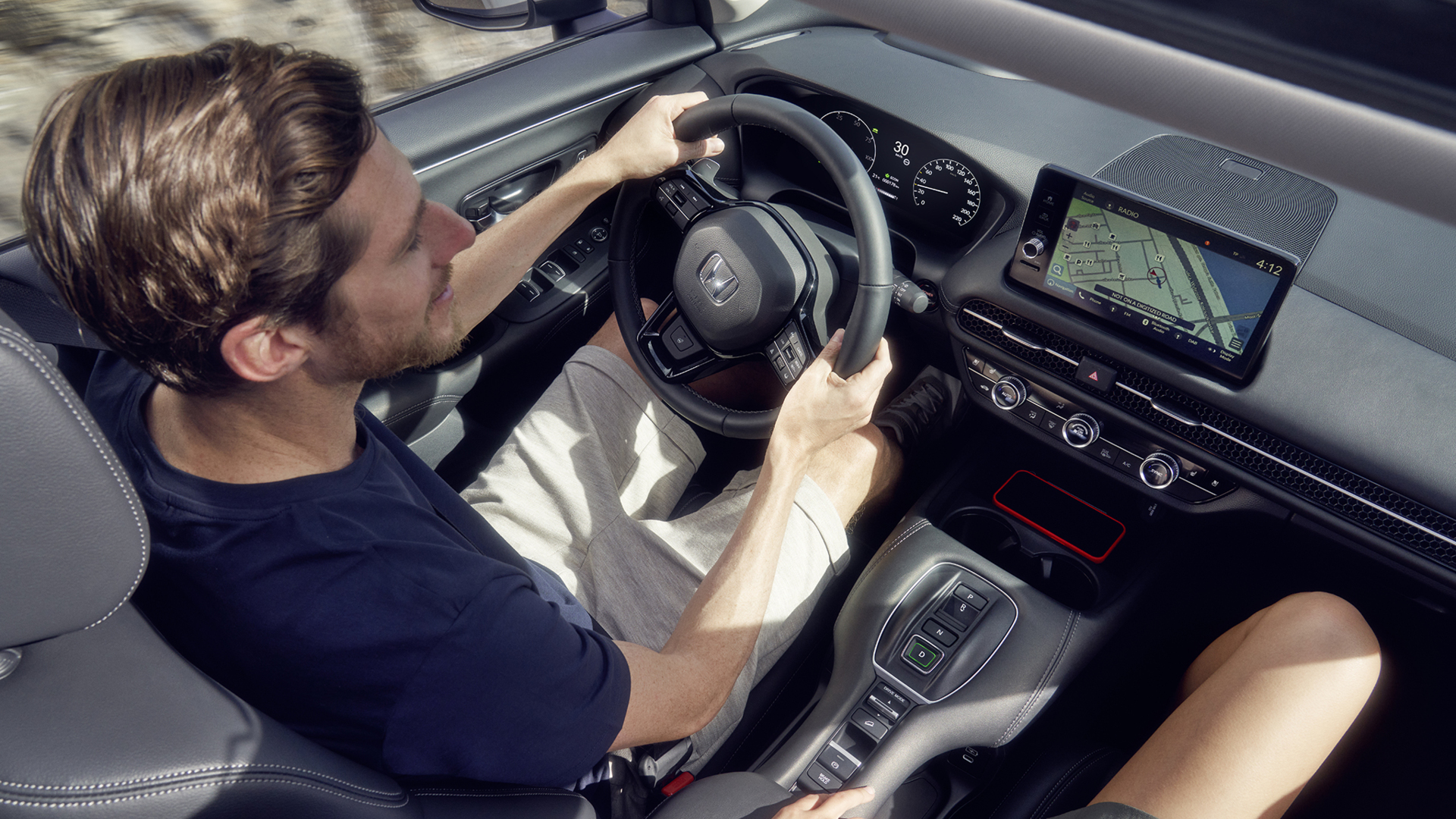 Homme conduisant un ZR-V avec navigation affichée sur le tableau de bord