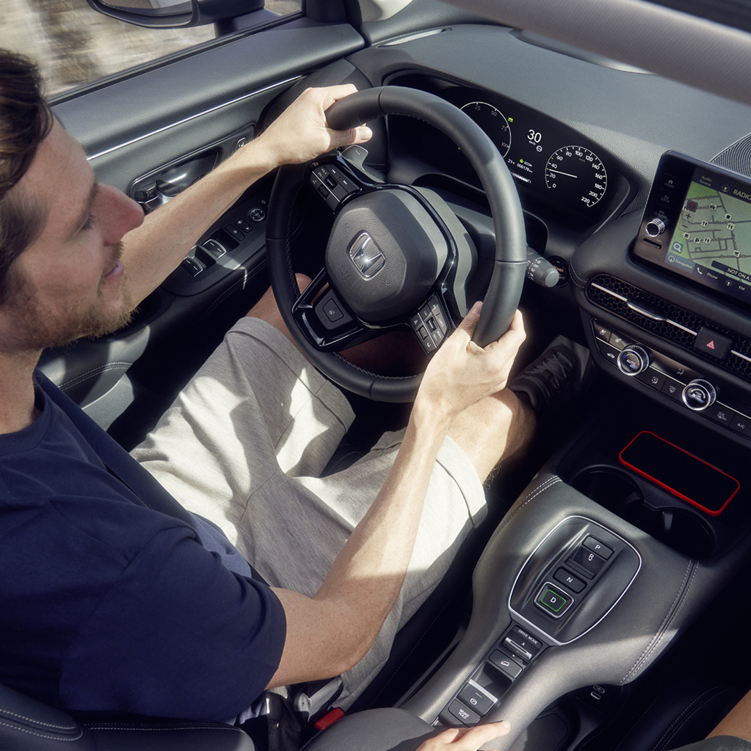 Homme conduisant un ZR-V avec navigation affichée sur le tableau de bord