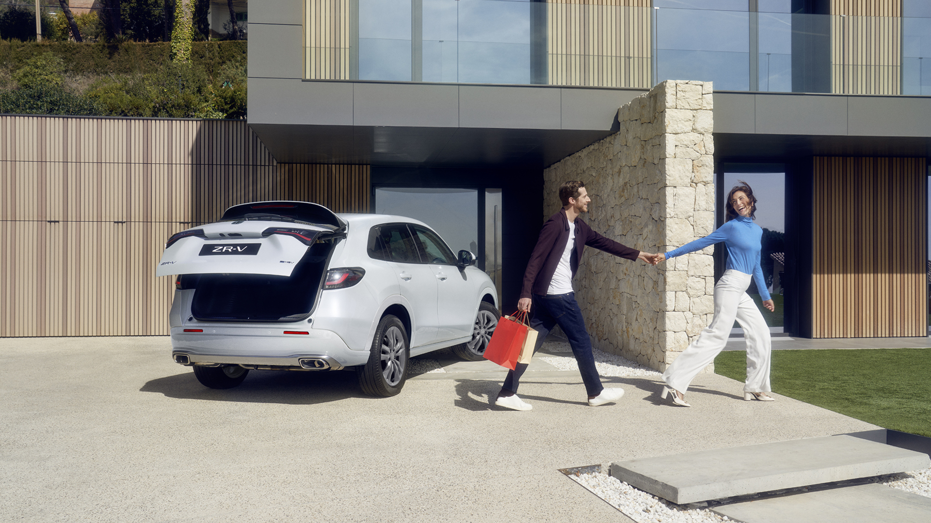ZR-V blanc dans une allée, hayon électrique ouvert