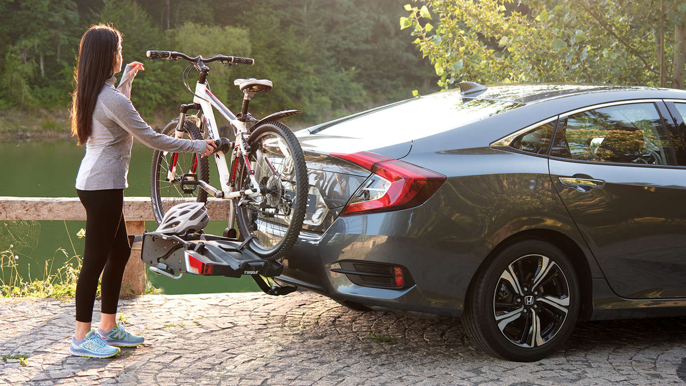 Vue latérale du modèle avec porte-vélos Thule dans la forêt