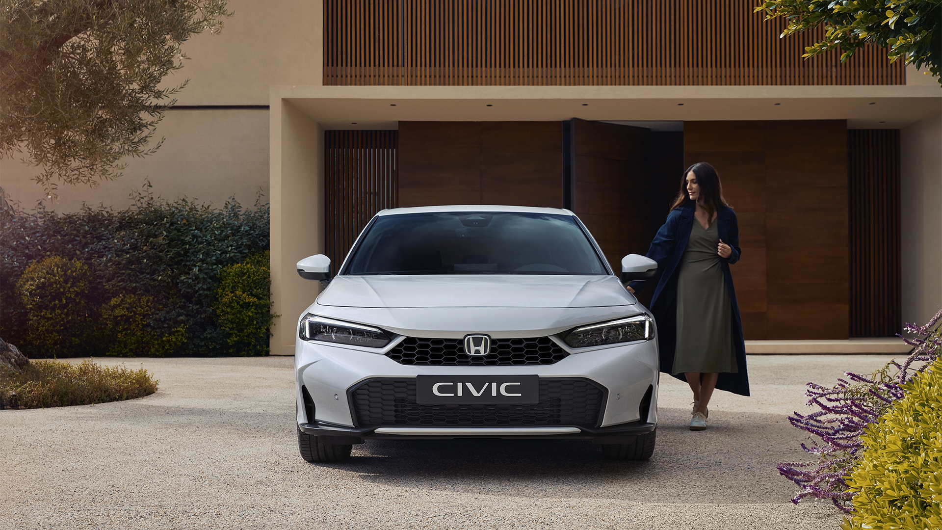 Plan de face d'une Civic Hybrid, avec une femme ouvrant sa porte.