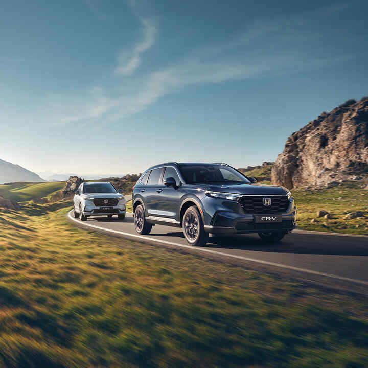 Vue de trois quarts avant d’un CR-V hybride de Honda dans un environnement montagneux.