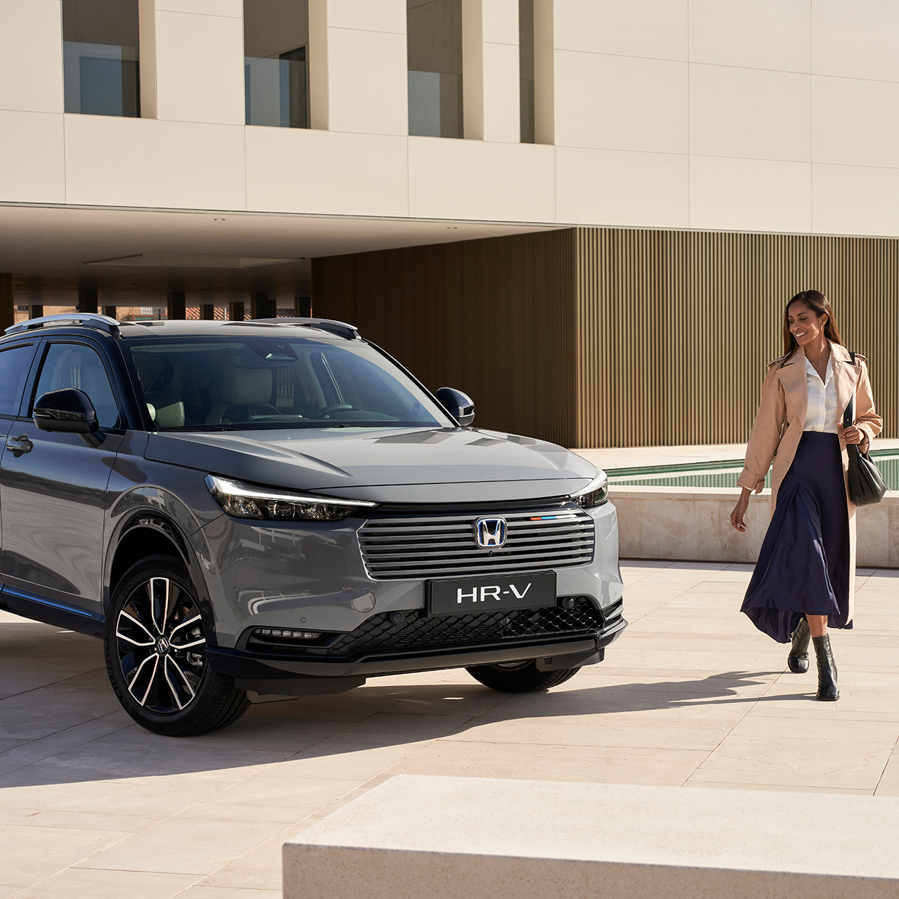 Couple marchant à côté d'un HR-V garé à l'extérieur d'un bâtiment. 