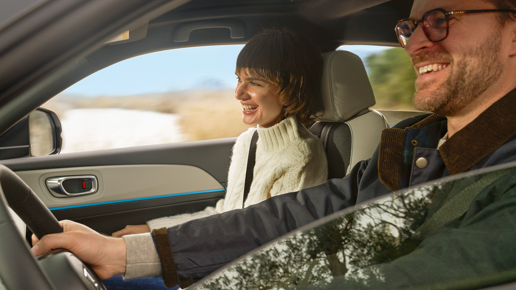 Couple souriant à l'intérieur de la voiture. 
