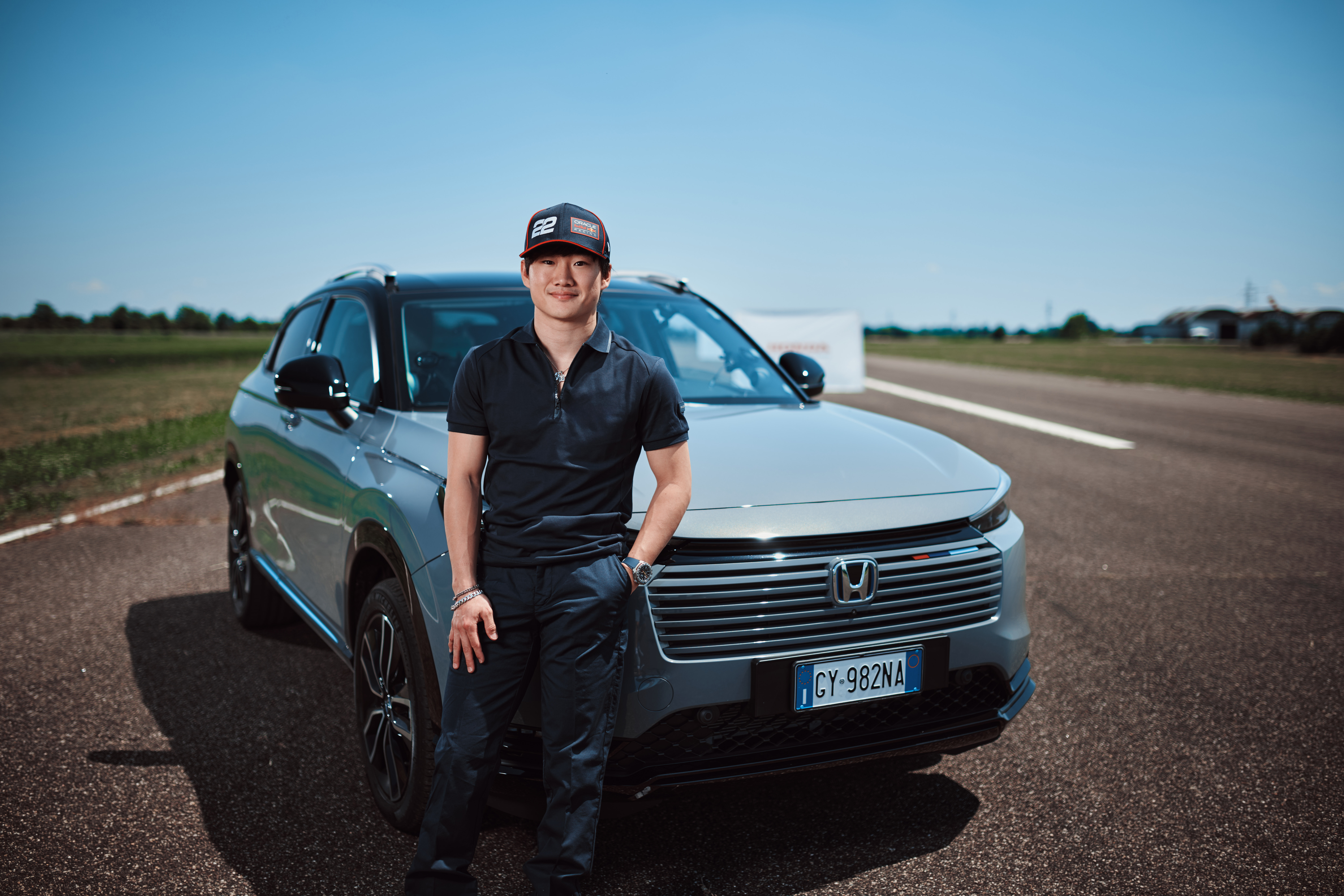Yuki debout à côté de la calandre avant du HR-V