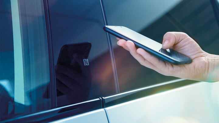 Gros plan de l'application My Honda+ sur l'écran du téléphone d'une personne se trouvant à l'extérieur d'un véhicule