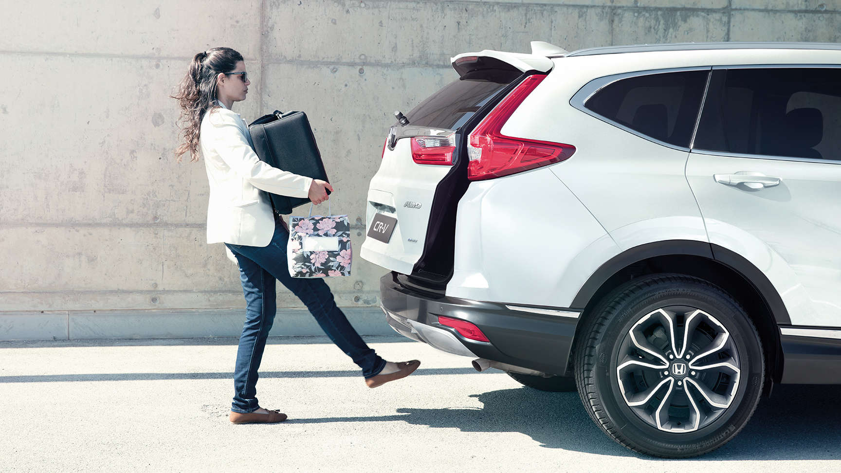 Femme chargeant l'arrière d'un CR-V