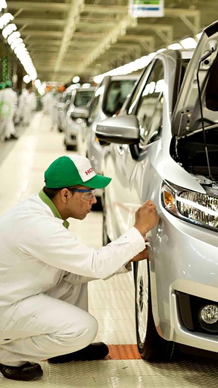 Technicien Honda travaillant sur une voiture à l'usine.
