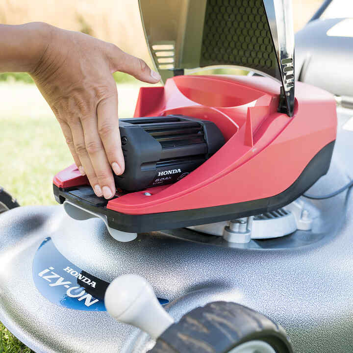 Homme réparant un taille-haie à batterie