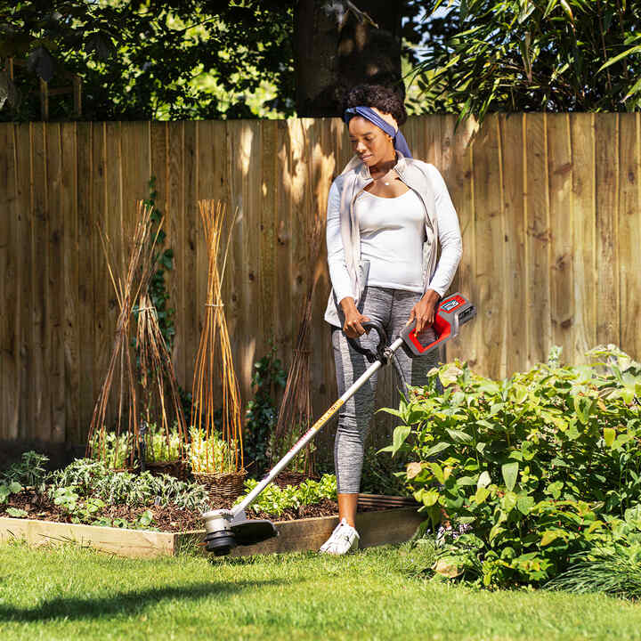 Femme utilisant une tondeuse à batterie