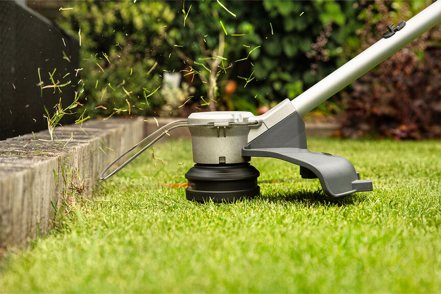 Coupe-bordure à batterie démontrant une ligne de coupe de haute qualité sur la pelouse.