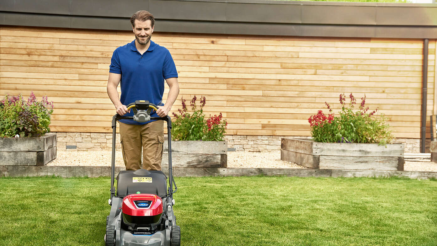 Homme poussant une Honda HRX dans un jardin