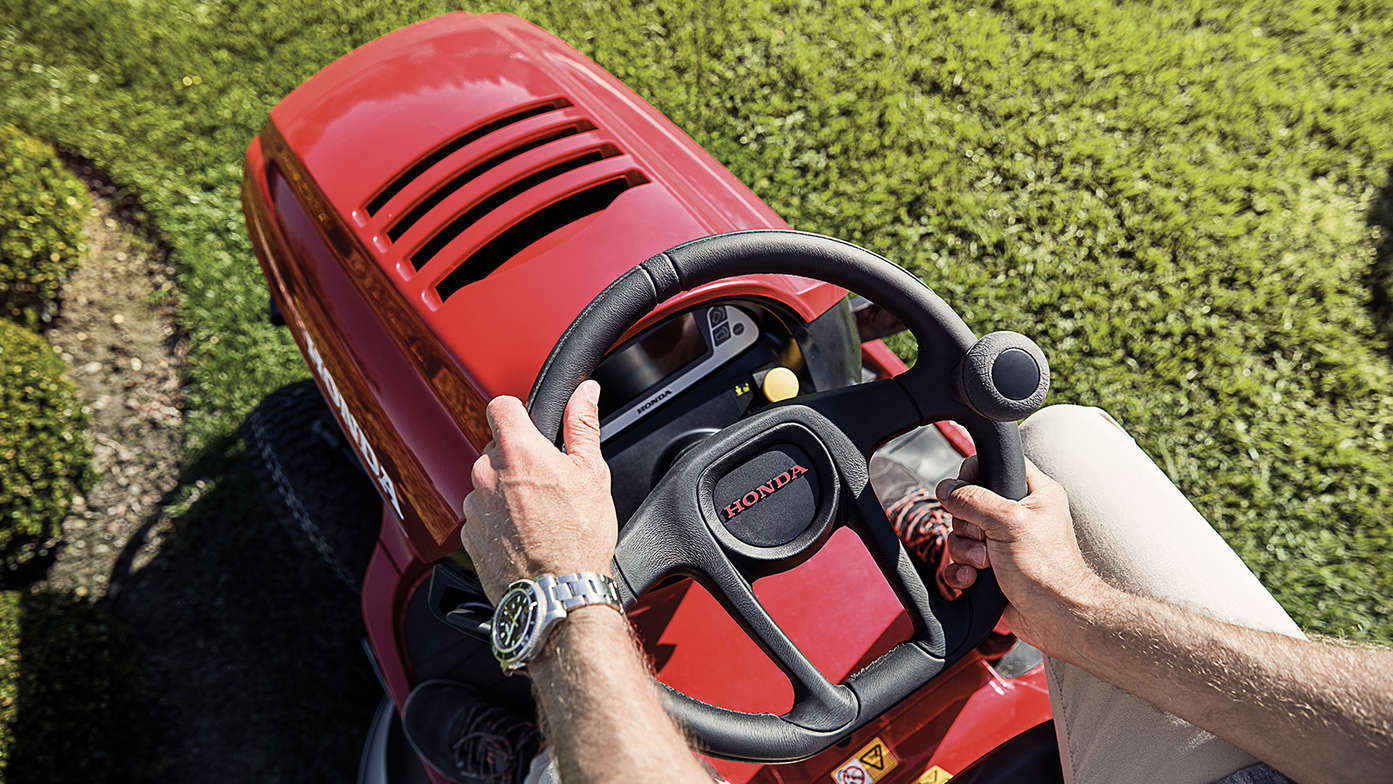 Vue de dessus du volant et de l'avant du tracteur avec les mains du modèle