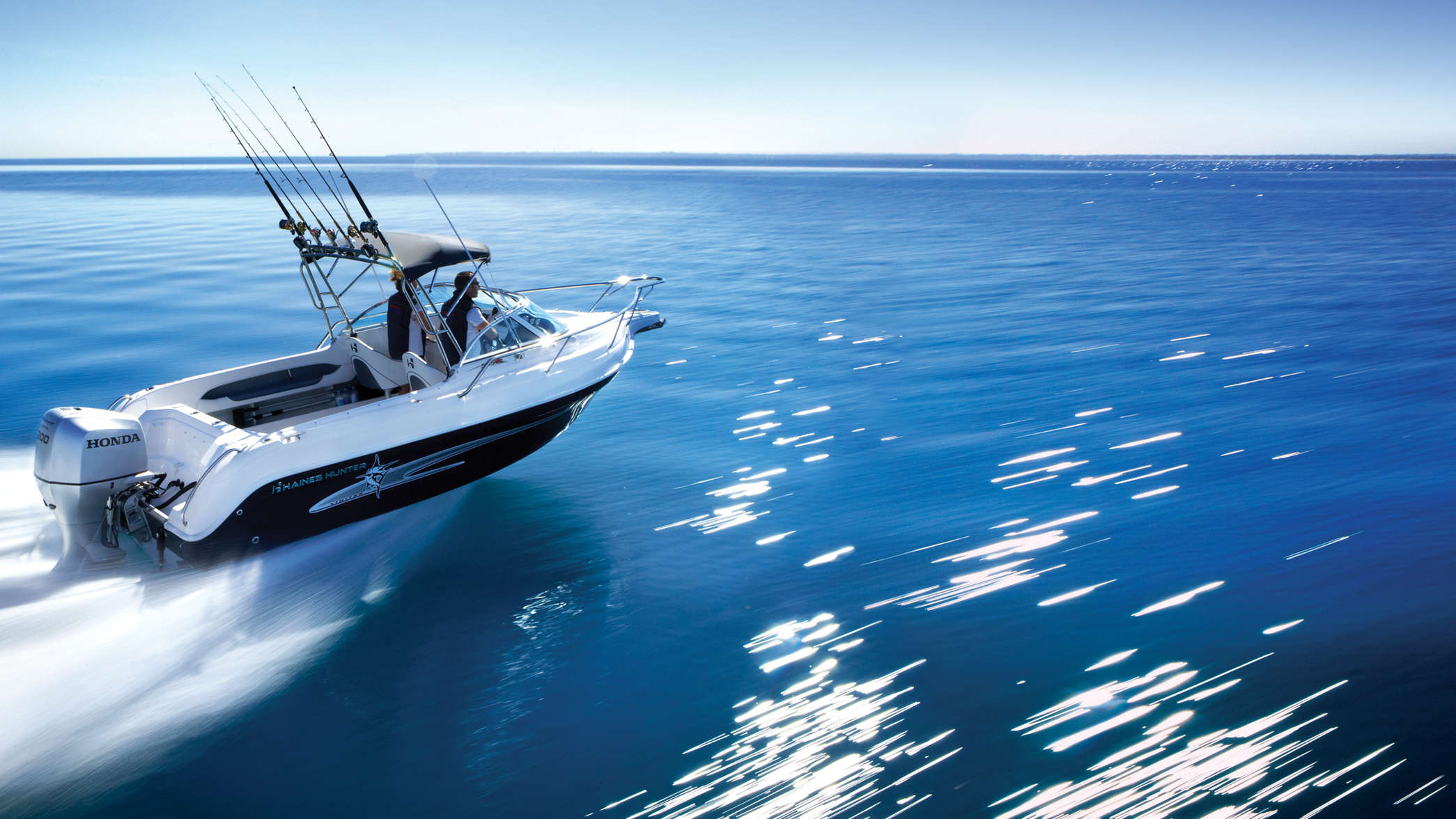 Boat using Honda engine demonstrating performance, being used by model, coastal location.