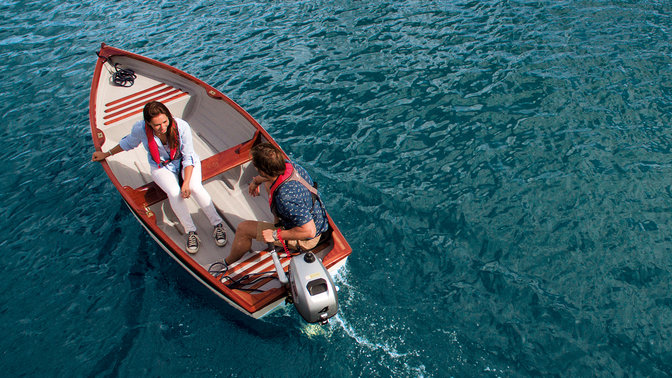 Couple souriant sur un bateau, vu de dessus.