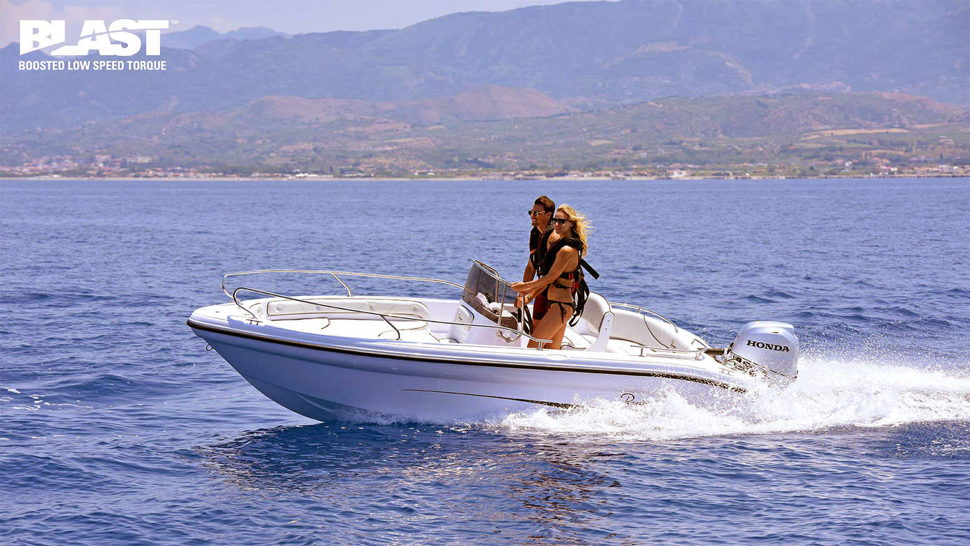 Boat using Honda engine, being used by models, coastal location.