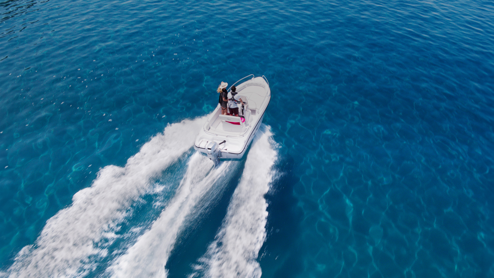Couple sur un bateau dans l'océan avec un moteur Honda BF.