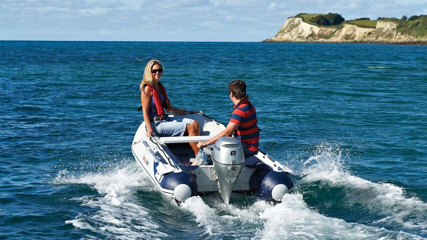 Mother and son riding a Highfield boat powered by a Honda BF8 outboard engine