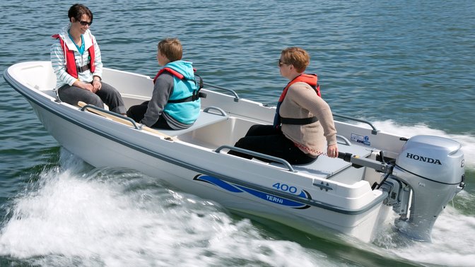 Boat with Honda engine, being used by models, coastal location.