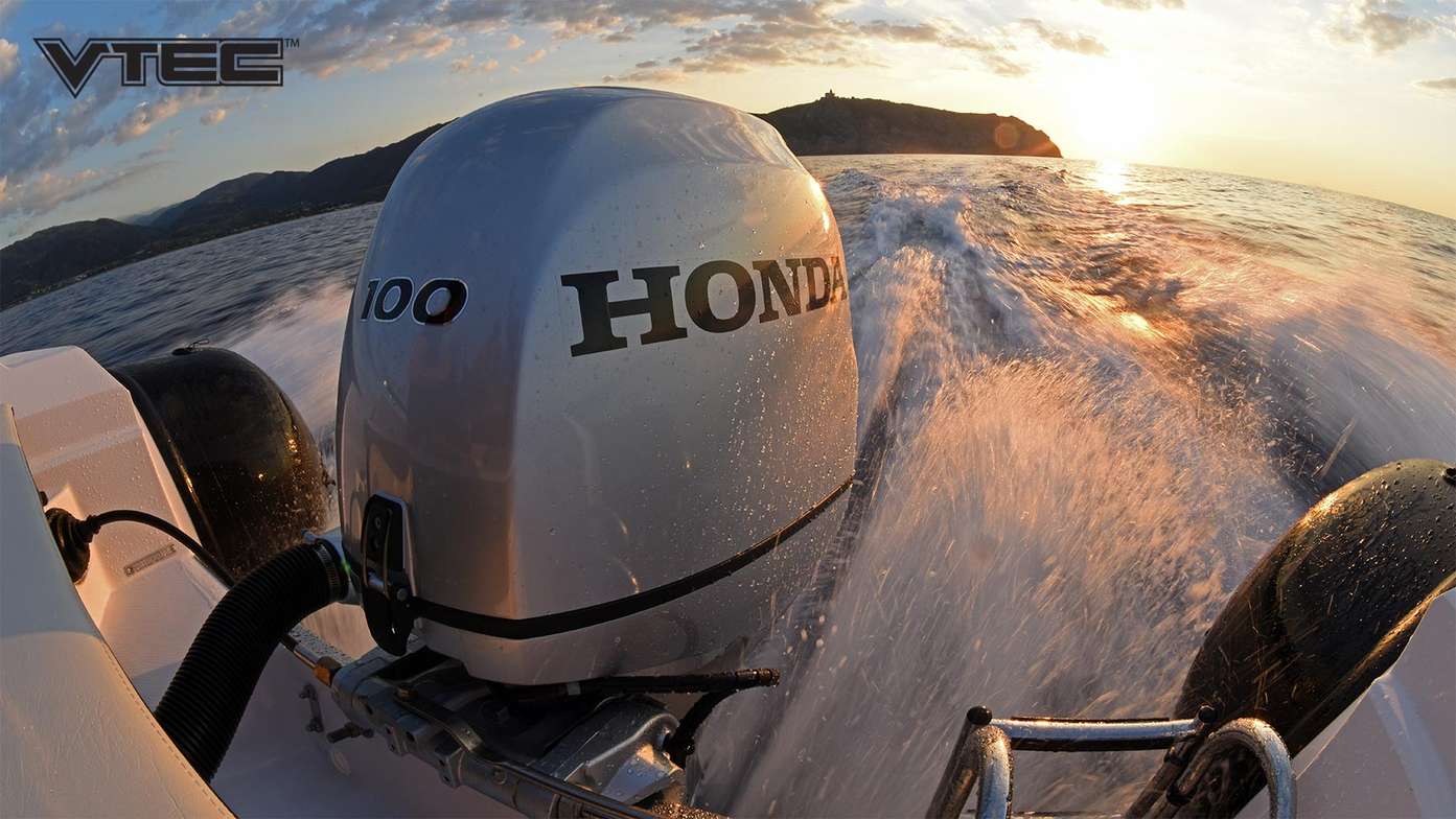Rear facing sunset view of a moving speed boat looking onto a Honda BF 100 outboard engine