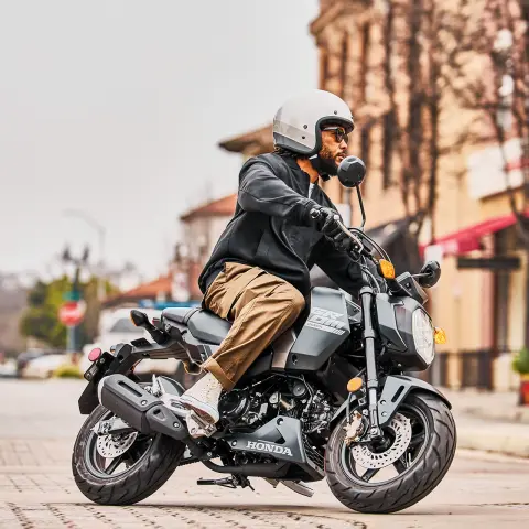 Image statique du MSX125 Grom avec le pilote sur le point de partir