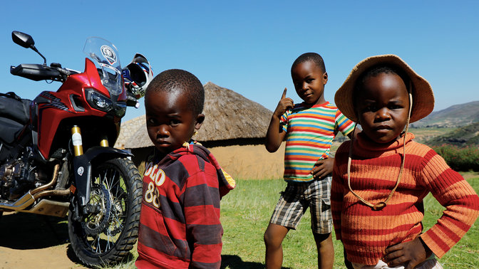 De jeunes enfants dehors rassemblés autour d'une CRF1000L Africa Twin
