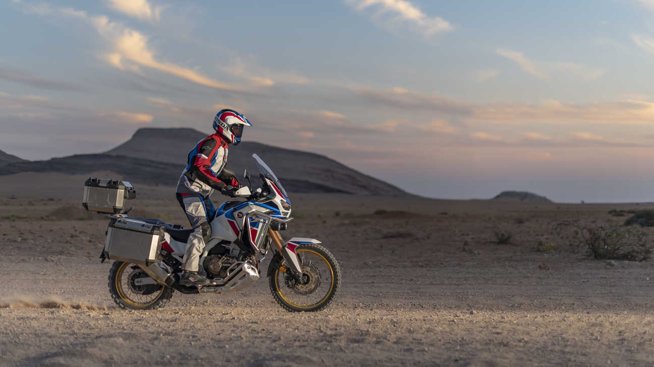 Côté droit du trail Honda Africa Twin Adventure Sports, piloté sur une piste de terre dans un paysage désertique