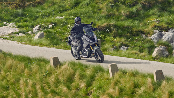 Pilote sur Honda X-ADV sur une route de montagne.