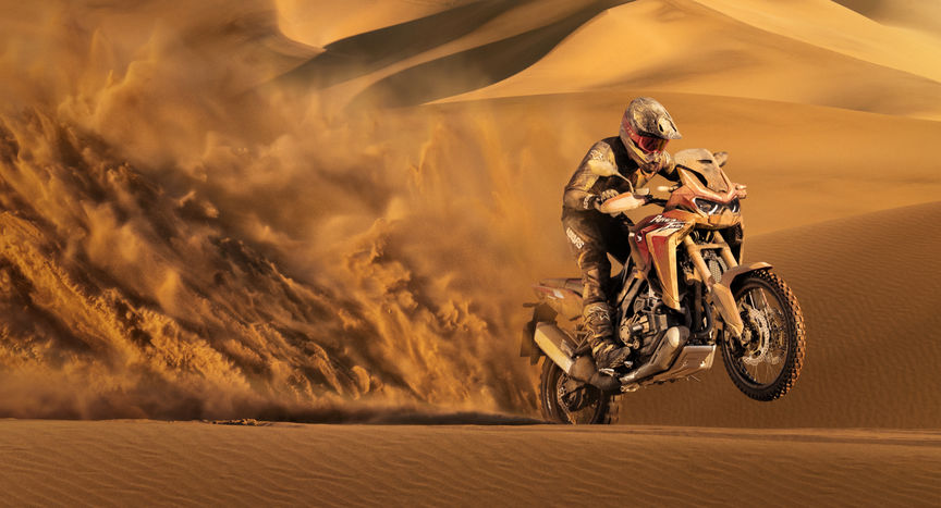 Trail Honda Africa Twin, vue de trois quarts avant droit, piloté dans le sable