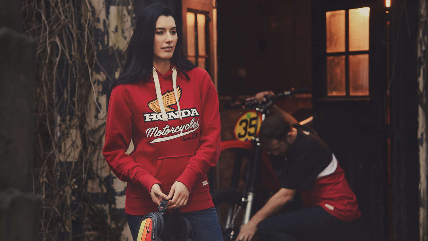 Un homme et une femme portant un sweat à capuche vintage Honda rouge. 