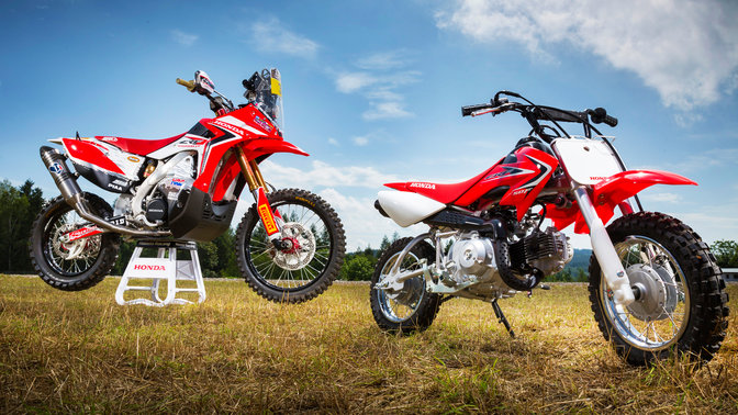 Vue de trois quarts latérale de la CRF50F, stationnée dans un champ. Vue de droite.