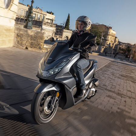 Honda PCX125 sur fond de paysage urbain
