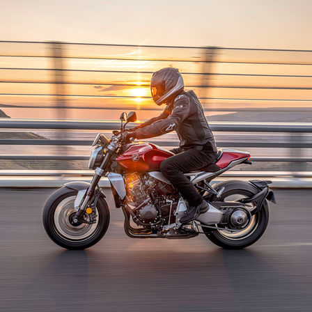 Côté gauche de la Honda CB1000R, avec pilote, sur route, avec lever du soleil