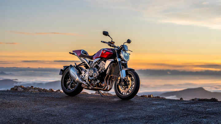 Vue de trois quarts avant droit de la Honda CB1000R, à l'arrêt, au-dessus des montagnes