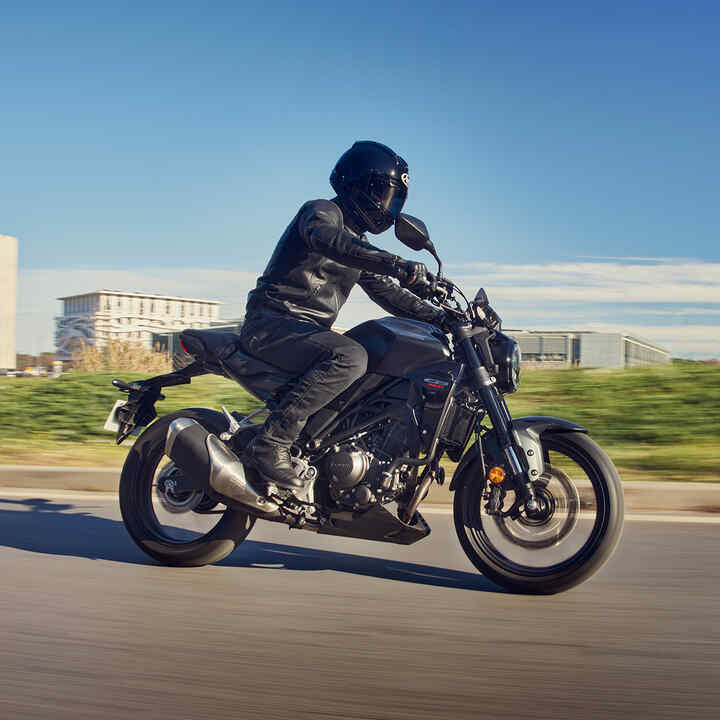 Vue de profil de la Honda CB300R en mouvement sur route.