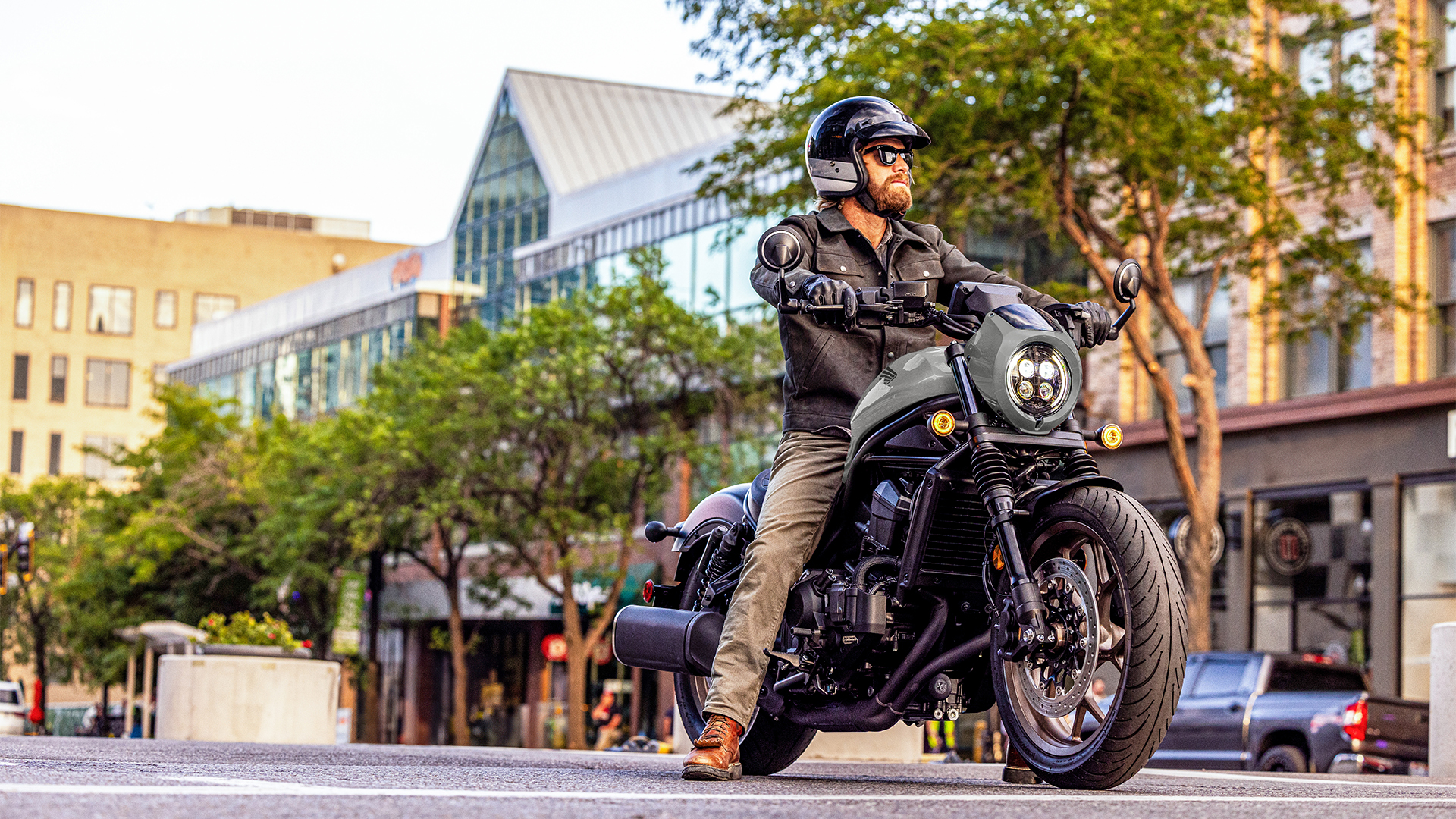 Personnage sur une Honda CMX1100 de face, en situation urbaine.