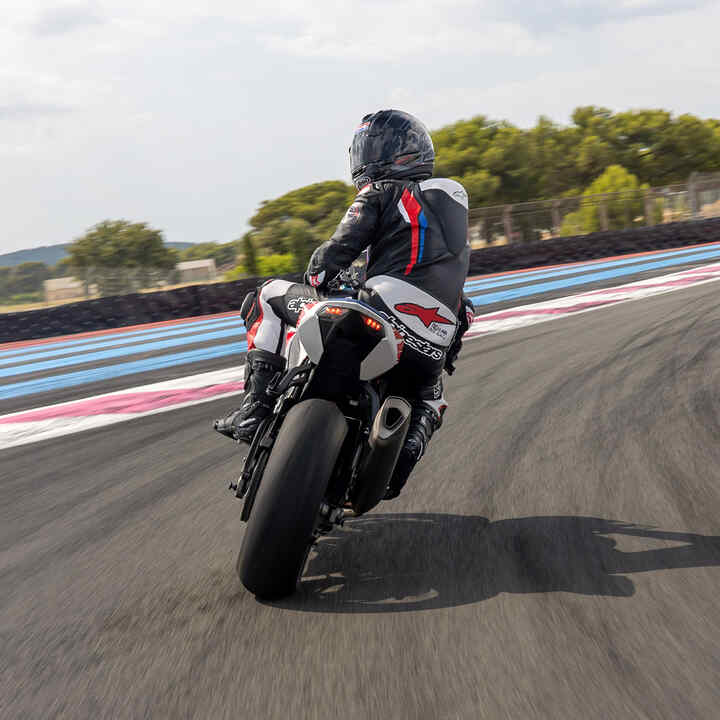 Vue latérale arrière de la Honda CBR1000RR-R Fireblade avec un pilote sur circuit