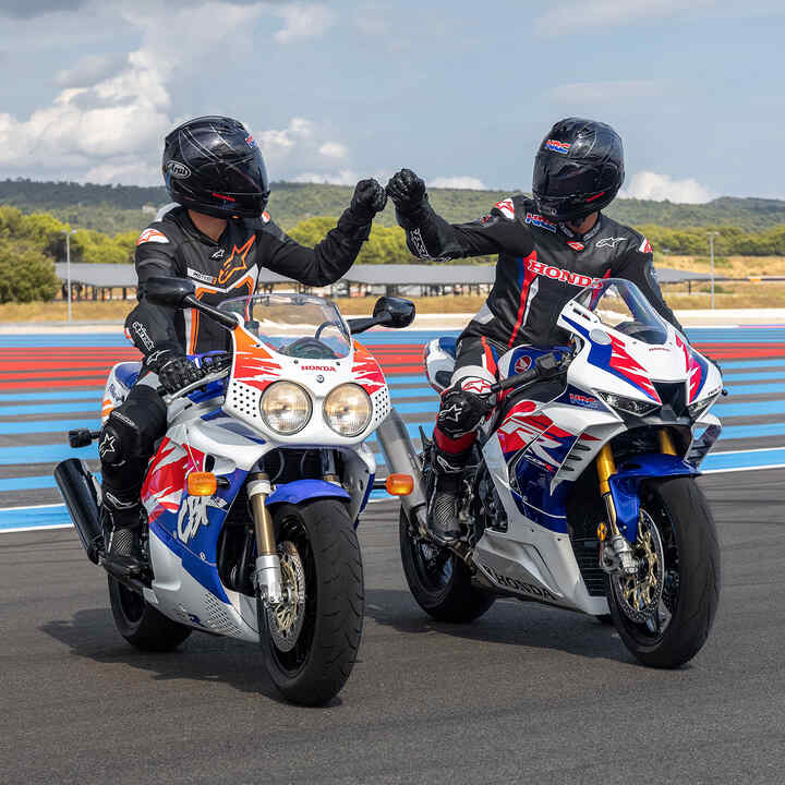 Deux pilotes sur des Honda Fireblade vues de face qui se congratulent sur la piste.