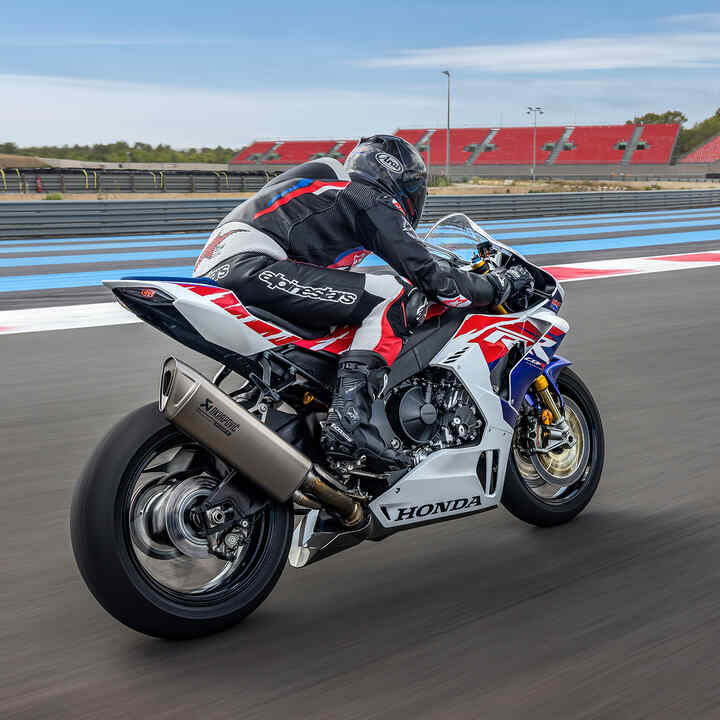 Vue de trois quarts avant de la Honda CBR1000RR-R Fireblade avec un pilote sur circuit.